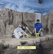 a man and a woman are feeding a seal in a bucket with the letters o on it
