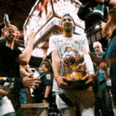 a man holding a trophy in front of a crowd