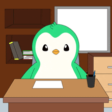 a green and white penguin sits at a desk with a pencil holder