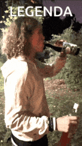 a person is drinking from a bottle with the word legenda on the bottom
