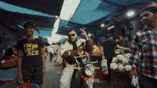 a man wearing a t-shirt that says i 'm in peace is riding a motorcycle