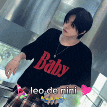 a young man wearing a black shirt that says baby