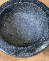 a black bowl sitting on a wooden surface