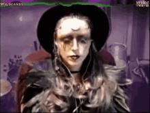 a woman in a witch costume is wearing a black hat .