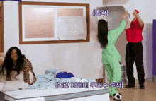 a woman in a green outfit is standing next to a man in a red shirt in a bedroom