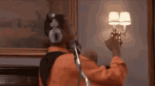 a man wearing headphones is standing in front of a microphone and singing into it .