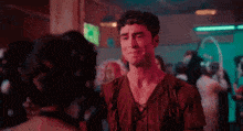 a man is crying while standing next to a woman in a club .