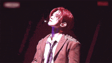 a man with red hair is wearing a suit and tie on stage