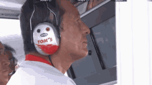 a man wearing a pair of headphones that say tom 's on them