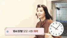 a woman with curlers in her hair is standing in front of a clock that shows the time as 10:13