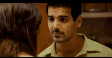 a man and a woman are looking at each other and the man is smiling .