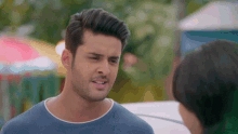 a man in a blue shirt is talking to a woman in a white car