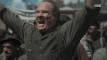 a man is screaming with his arms in the air in front of a crowd with hbo written on the bottom of the screen