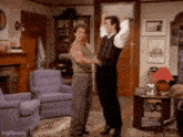 two men are dancing in a living room with purple chairs .