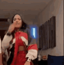 a woman is dancing in a living room while holding a microphone .