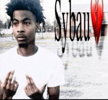 a young man giving the middle finger in front of a broken heart that says sybau