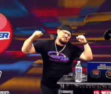 a man flexes his muscles in front of a dj racer sign