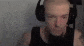 a man with a beard is wearing headphones and a microphone while playing a video game .