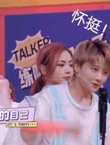a man and a woman are talking into microphones .