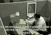a man is sitting at a desk in front of a computer and waiting for him like for four weeks .