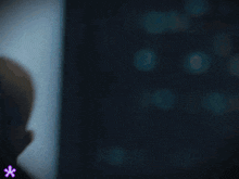 a person sitting in front of a window with the letter c on the bottom right