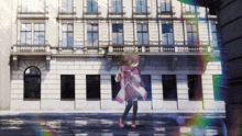 a girl in a pink dress stands in front of a large building