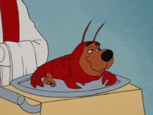 a cartoon dog dressed as a lobster sits on a table
