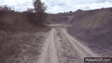 a dirt road with the words makeagif.com at the top