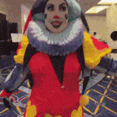 a woman in a clown costume is standing in a room and smiling