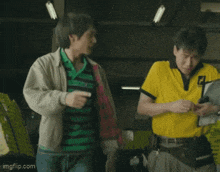 a man in a green and black striped shirt and a man in a yellow shirt are standing next to each other