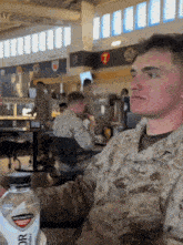 a man in a us marines uniform sits at a table in a restaurant