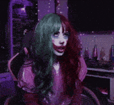 a woman with green and red hair is wearing a clown makeup