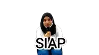 a woman in a hijab is kneeling down with a microphone in her hand and the word siap written on the bottom .