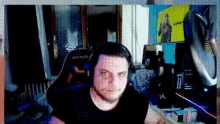 a man wearing headphones and a black shirt is sitting in a gaming chair .