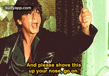 a man is screaming and holding his fist up in the air .