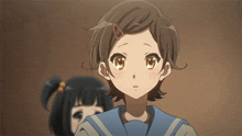a girl with a red ring in her hair looks at the camera