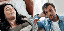 a woman in a hospital bed next to a man in a denim jacket