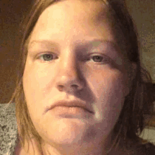 a close up of a woman 's face with an angry look on her face .