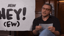 a man in front of a sign that says hey