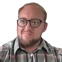 a man wearing glasses and a plaid shirt is looking at the camera