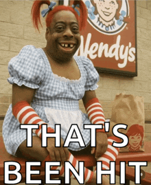a wendy 's sign is behind a person in a wendy 's costume
