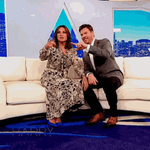 a man and a woman are sitting on a couch with the word harry in the background