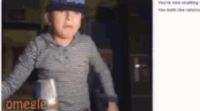 a young boy wearing a hat is standing in a dark room .