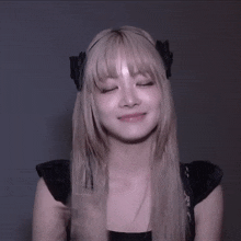a woman with blonde hair wearing a headband with a bow on it