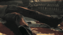 a close up of a person laying on a bed with a skull on their face .