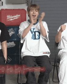 a man wearing a milwaukee shirt is clapping