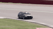 a car is driving on a race track with a red sign in the background that says ' bmw '