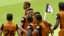 a group of soccer players are huddled together and one of them has the number 26 on his back