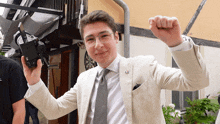 a man in a suit and tie holds a camera in his hand