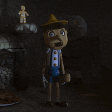 a gingerbread man is standing next to a wooden pinocchio doll